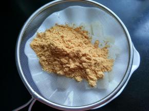 将黄豆粉筛入盘中。