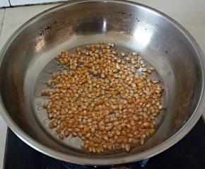 把色拉油跟爆裂玉米放入锅中，拌均匀。