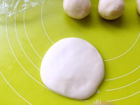 取一份水油皮面团，用擀面杖擀成圆片，中间厚一点，四周薄一点