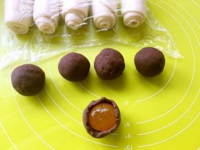 用手掌将豆沙压扁，包裹上咸蛋黄，之后一点点推豆沙将收口收好