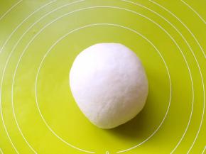 混合水油皮材料，活成面团，之后倒在揉面垫上，一直推揉至面团表面光滑，盖保鲜膜松弛