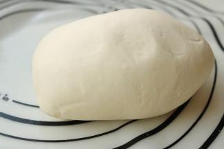 醒发后的面团再次移到揉面垫上，再次揉5分钟，面团变得细腻光滑，延展性也很好，这样的面团待会才会容易擀开。