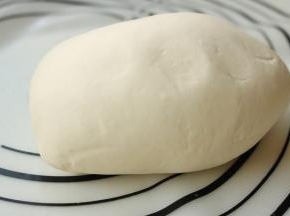 醒发后的面团再次移到揉面垫上，再次揉5分钟，面团变得细腻光滑，延展性也很好，这样的面团待会才会容易擀开。