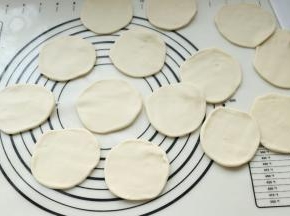 把面剂子擀开成饼状，不用擀太大，待会还要再次操作。