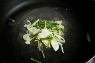 炒锅放油，先放入香菜茎葱姜丝炒香。