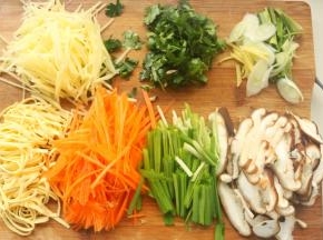 蒸饼的时候开始准备蔬菜。我准备了胡萝卜、豆腐皮、韭菜、香菇、土豆和绿豆芽，不仅好吃而且五颜六色。土豆去皮切成丝，胡萝卜切成丝，香菇切薄片，豆腐皮切成丝，韭菜切段，香菜茎和叶子分开切碎，葱姜切丝。