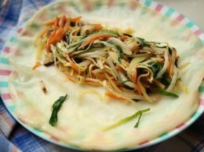 春饼铺在盘子里，放上刚才炒好的蔬菜，我喜欢多多的卷菜进去，这样才好吃。