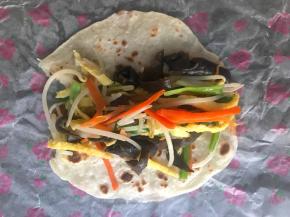 把配菜放在面饼上，卷起