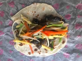 把配菜放在面饼上，卷起