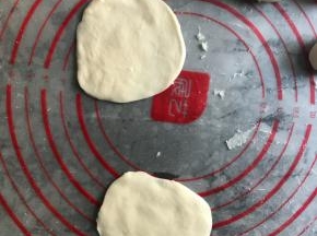 案板上抹油，取两个剂子按扁成圆形