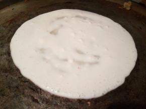 刷少许油，铲子舀一勺面糊，从中间开始往四周摊，想吃大的，摊大一点，摊好以后，盛出多余的面糊