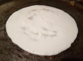 刷少许油，铲子舀一勺面糊，从中间开始往四周摊，想吃大的，摊大一点，摊好以后，盛出多余的面糊