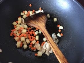 再放入胡萝卜土豆翻炒至土豆表面呈金黄色