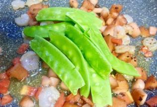 锅内的食材炒至8成熟放入荷兰豆一起炒