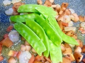 锅内的食材炒至8成熟放入荷兰豆一起炒
