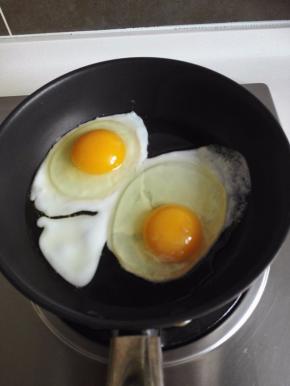 锅中倒入植物油，中火加热，打入2个鸡蛋，先煎荷包蛋