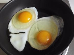 锅中倒入植物油，中火加热，打入2个鸡蛋，先煎荷包蛋