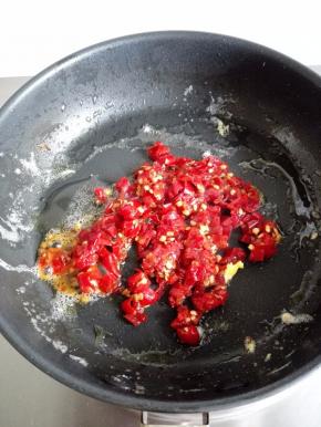 利用锅中的底油，放入泡椒碎小火炒香