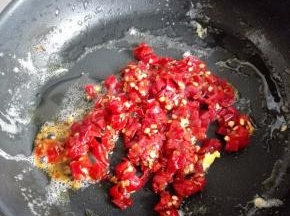 利用锅中的底油，放入泡椒碎小火炒香