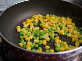 另起锅加适量油，倒入玉米粒和豌豆
