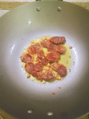 锅里放油爆香蒜末。放入辣肠炒香。