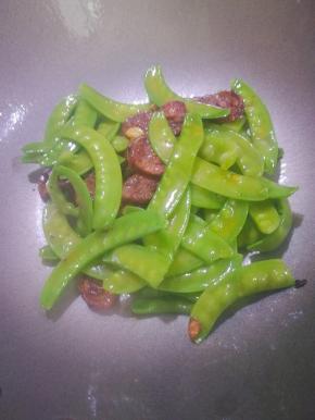 放入荷兰豆翻炒均匀。调入盐放入一点点清水稍微焖一下。