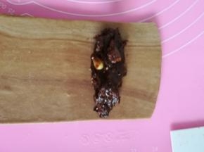 冷冻松弛好的面团擀开切成12个宽7厘米左右，长18厘米的长条，放一个冷藏成型的巧克力条卷起。