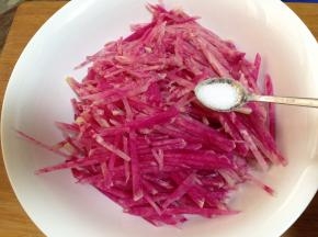 萝卜丝入碗加入一点盐拌匀（盐的量不要多，一点点就行)