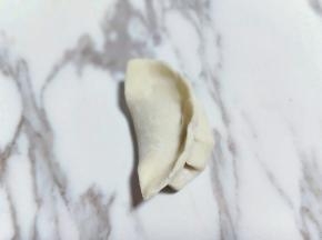 之后再把另一端捏起来，一定要捏紧，这样饺子包好了。