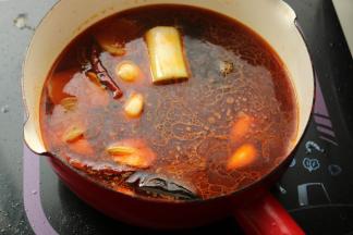 加入高汤和调料。我用了红油和麻辣油，这样就不需要加花椒，时不时咬到花椒叶是很烦人的。高汤煮开后煮1分钟，沸腾过程中会更好的使香味散发出来。