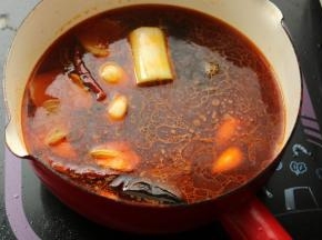 加入高汤和调料。我用了红油和麻辣油，这样就不需要加花椒，时不时咬到花椒叶是很烦人的。高汤煮开后煮1分钟，沸腾过程中会更好的使香味散发出来。