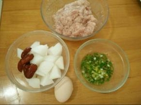 首先处理好食材。猪肉剁成泥，萝卜切成小块，红枣洗干净去核，葱花和姜加入温水做成葱姜水。