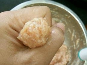 这时候可以放肉丸了，先用虎口轻轻挤出肉泥，再用不锈钢勺子把肉丸挑到锅里。