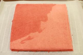 蛋糕片出炉后盖上油纸，倒扣放至温热，将蛋糕片边缘切整齐