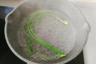 锅中烧热水，先放蒜苔焯下水