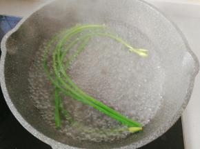 锅中烧热水，先放蒜苔焯下水