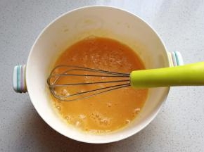 鸡蛋打入大碗中，加入淀粉和少许牛奶搅拌均匀，然后过筛一次备用