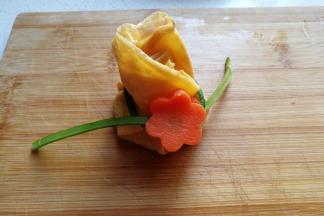 然后把蒜苔结拉松，把胡萝卜花分开挂上去，再把蒜苔系紧