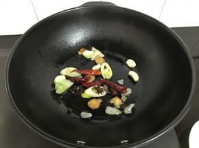 炒至冰糖融化后放入桂皮、八角、干辣椒。