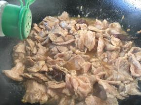 改中火，放入腌制好的肉片，当肉片稍稍变色定形型时放入1小勺白胡椒粉并翻炒，让肉均匀受热。