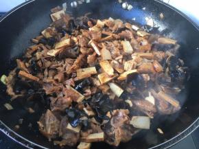 改大火，放入香干、面筋、木耳、花菜，香菇、笋干翻炒均匀。