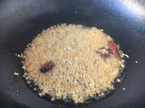 开大火置锅，锅内留炒虾仁底油，再加入油（油总量是平时炒肉时的2倍），改中小火，放八角，当八角煸出香味时依次放入姜米、蒜片葱花、辣椒爆香。