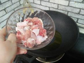 有热，加入鸡腿块，炒至肉色发白