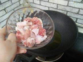 有热，加入鸡腿块，炒至肉色发白