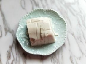 把内酯豆腐从盒子中倒扣出来，放入盘子中。