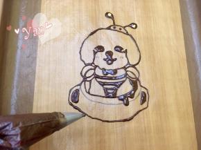 10、用黄、浅棕、深棕色素调出三色面糊，用深棕色面糊勾出线条，放入预热好的烤箱，165度烤2分钟；