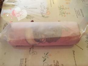 用擀面杖卷住油纸，顺势往上推。卷起来，两边跟拧糖一样拧起来。放入冰箱冷藏半小时后再切块食用。