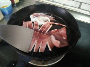 平底锅刷适量油，鱿鱼放在锅上，用铲子把鱿鱼身铲一下