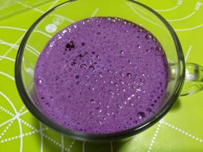 搅打好的蓝莓牛奶倒入杯子里。