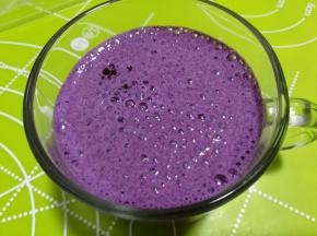 搅打好的蓝莓牛奶倒入杯子里。